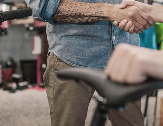 Dos personas dándose la mano en la compraventa de una bicicleta