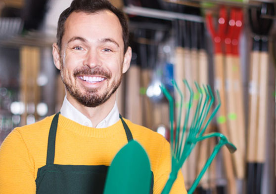 Trabajador de jardinería sonriendo a cámara